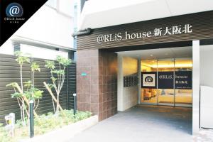 大阪@RLiS_house新大阪北的建筑前有标志的商店
