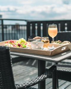 奥斯陆奥斯陆第一千禧酒店的桌上的食品和一杯葡萄酒