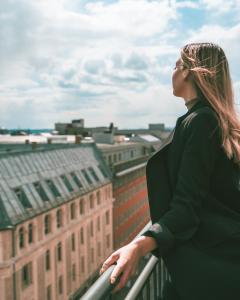 奥斯陆奥斯陆第一千禧酒店的站在一个俯瞰城市的阳台上的女人