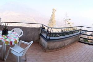 PellezzanoCollina Belvedere, appartamento indipendente in villa Salerno-Capezzano的设有一个配有桌椅并享有美景的阳台。