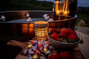 奥托罗杭阿Orchard Valley Glamping的热水浴池旁的桌子上放上一碗草莓