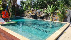 马塔兰Dewi Sri Guesthouse的度假村内带瀑布的游泳池