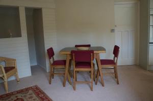 曼海德Minehead mews cottage的餐桌,带四把椅子和碗