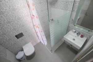 萨兰达Amaris的浴室配有卫生间、盥洗盆和淋浴。