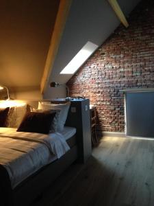 赫伦塔尔斯德罗姆泽特住宿加早餐旅馆的一间卧室设有一张床和砖墙
