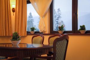 锡纳亚弗洛里酒店的一间带桌椅和窗户的用餐室