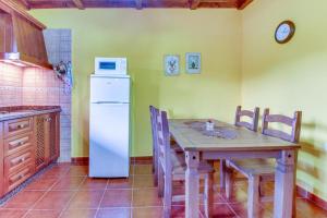 ArafoVilla Morera的厨房配有木桌和白色冰箱。
