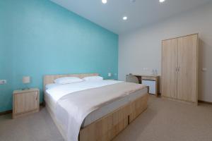 伊热夫斯克Кипарис Отель的一间卧室设有一张蓝色墙壁的大床