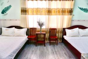 芹苴Lime Hostel - Ninh Kieu Center的一间设有两张床和一张桌子及椅子的房间