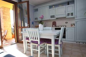 托斯科拉诺-马德尔诺Casa Mirella - Toscolano Maderno的白色的厨房配有白色的桌子和椅子