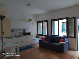 威尼斯Residenza Ca' Matta的一间带蓝色沙发的客厅和一间厨房
