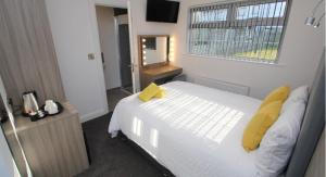 波特拉什Guest Rooms @ 128的卧室配有白色床、黄色枕头和窗户