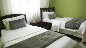 TororoMAMIKKI Hotel Apartments的一间卧室设有两张床和窗户。