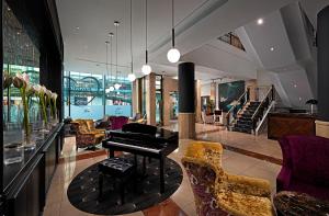 利默里克萨弗伊酒店的客厅配有钢琴和一些椅子