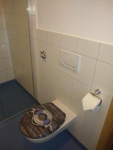 安格尔明德Ferienwohnung Amende的一间带卫生间和木座椅的浴室