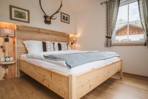 巴德哥依斯恩Ferienwohnungen Villa Salzweg的一间卧室配有一张带木制床头板的床
