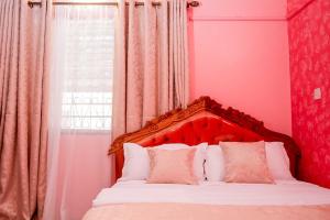 基利菲Dondoo's Paradise- Perfect Vacation Home的一间卧室配有一张带红色床头板的床和窗户