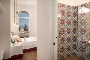 伊斯基亚Casa al Sole Boutique Hotel的一间带淋浴的浴室和瓷砖墙