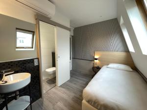 巴黎圣日耳曼酒店的一间卧室配有床、水槽和卫生间