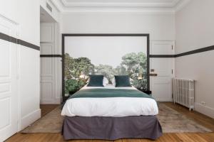 巴黎笑颜精品酒店的一间卧室设有一张大床和一个大窗户