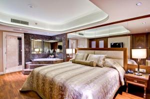 伯萨万寿菊温泉及水疗布尔萨酒店 的一间卧室设有一张大床和一个浴缸