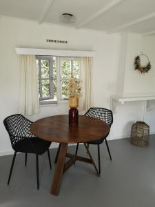 马尔克洛Het Nijhuisje的一间带木桌和两把椅子的用餐室