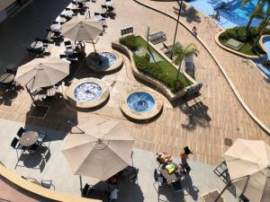 卡达斯诺瓦斯Alta Vista Thermas Resort的享有带桌子和遮阳伞的游泳池的顶部景致