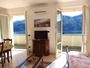 贝拉吉奥Casavalery Appartamento monolocale con vista lago的带电视的客厅和阳台。