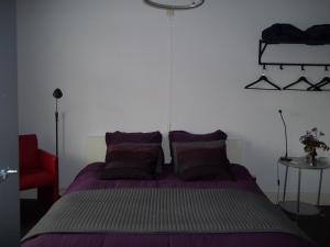 Wijckel't Griene Hemeltsje的一间卧室配有紫色的床和红色椅子