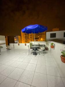 利马Apartamento Independiente 1 dormitorio cama Queen的一个带桌子和蓝伞的庭院