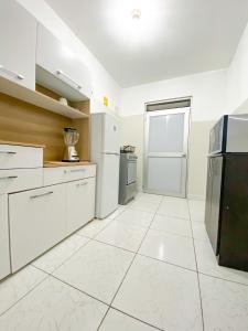利马Apartamento Independiente 1 dormitorio cama Queen的空厨房配有白色橱柜和冰箱