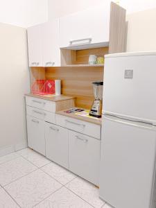 利马Apartamento Independiente 1 dormitorio cama Queen的厨房配有白色橱柜和冰箱。