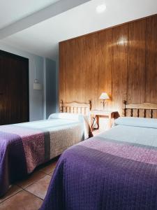 阿尔巴拉辛Hotel Valdevécar的两张位于酒店客房的床铺,配有紫色床单