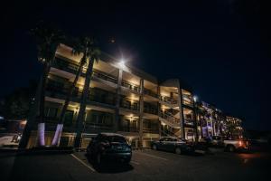 墨西卡利卡拉菲亚酒店的一座有汽车在晚上停在停车场的建筑