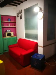 Isola del GiglioALLOGGIO S.ANNA的客厅里的一个红色沙发,配有微波炉