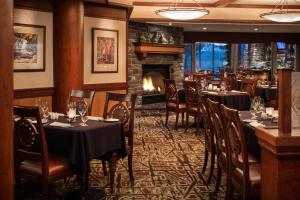 班夫Royal Canadian Lodge的一间带桌椅和壁炉的餐厅