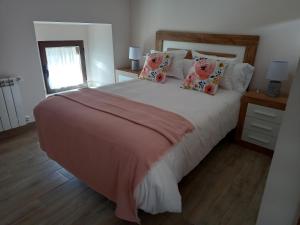 TrevejoLa Lagareta de Olivia的卧室配有一张大床,配有粉色床单和枕头