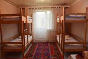 纳伦Naryn Guest House的一间设有四张双层床和地毯的房间