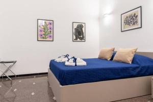 阿尔本加LargoDoria - ViaArchivolto, box auto privato incluso的一间卧室配有蓝色的床和毛巾