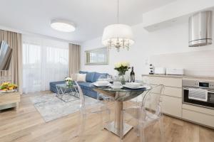 科沃布热格Baltini Premium Apartament Bliżej Morza的厨房以及带桌椅的起居室。