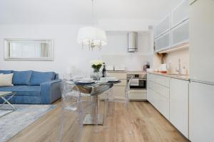 科沃布热格Baltini Premium Apartament Bliżej Morza的厨房以及带桌子和蓝色沙发的客厅。