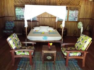 Nosy KombaKomba Forever的一间卧室配有一张床、两把椅子和一张桌子