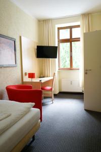 格尔利茨Gästehaus Lisakowski Pension am Brautwiesenpark的配有一张床、一张书桌和一扇窗户的酒店客房