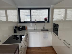 圣吉尔根Modern Living Sankt Gilgen的白色的厨房设有水槽和窗户
