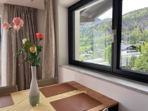 圣吉尔根Modern Living Sankt Gilgen的窗前桌子上花的花瓶