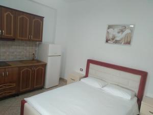 卡萨米尔Villa Shpetim Zogaj.的一间卧室配有一张床,厨房配有冰箱
