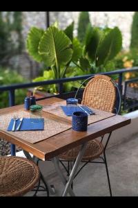 尼翁Coco Marco Hôtel的一张带两把椅子的木桌和一张带餐具的桌子