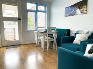 Gorran HavenSunnyVale Valley View Cottage的客厅配有桌子和蓝色沙发