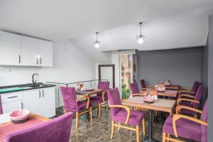 伊斯坦布尔La Petite Maison Hotel的一间用餐室,配有紫色的椅子和桌子