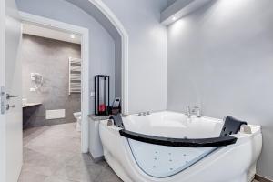 罗马Maison Degli Artisti Suites的白色的浴室设有浴缸和水槽。